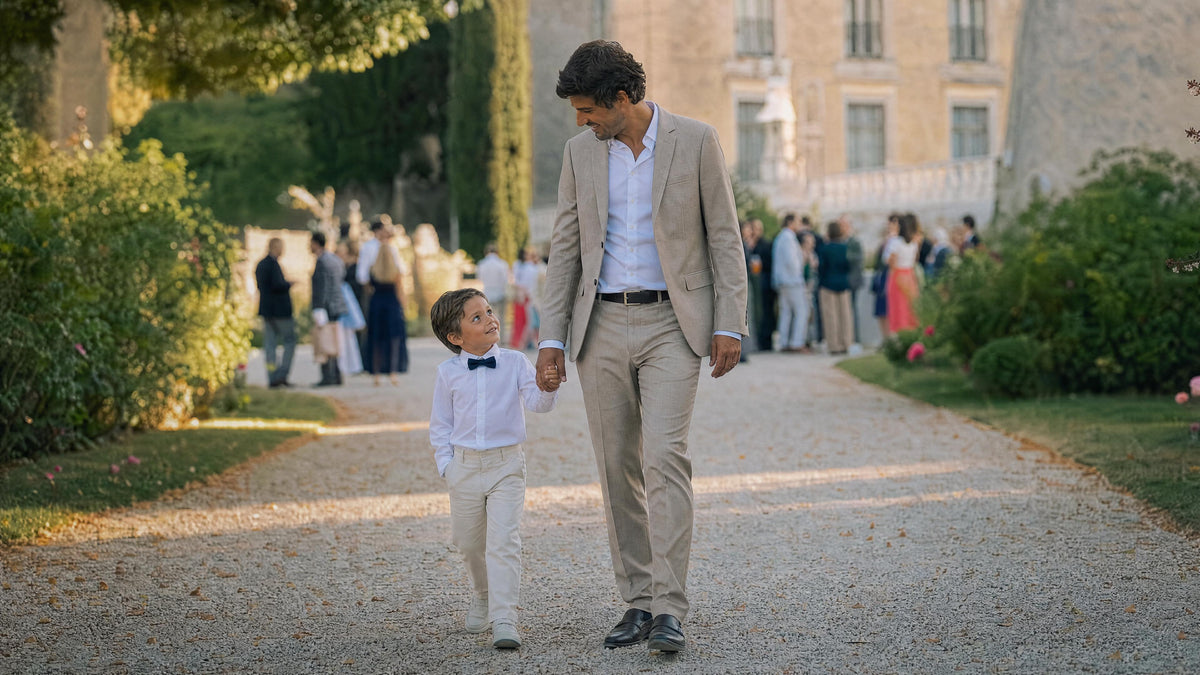 Enfant habillé pour un mariage marchant avec un adulte, tenue élégante et confortable. Kuva
