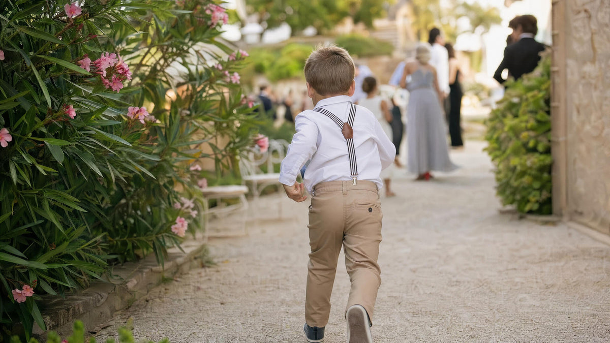 Enfant portant des bretelles pour une cérémonie, tenue élégante et naturelle. Kuva